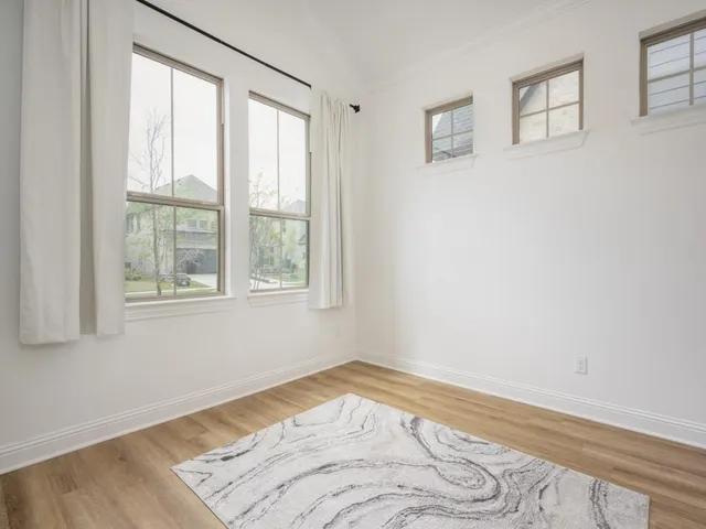 a view of a bedroom with wooden floor and a window