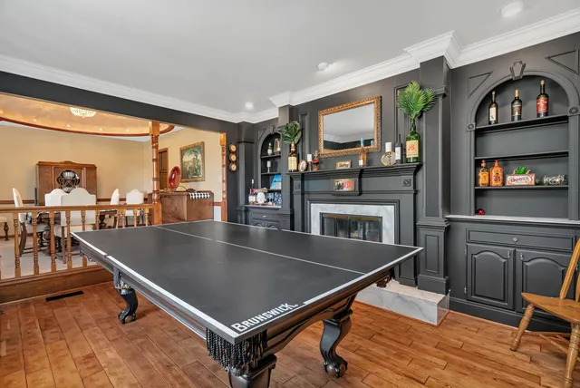 a living room with pool table a flat screen tv and floor to ceiling window
