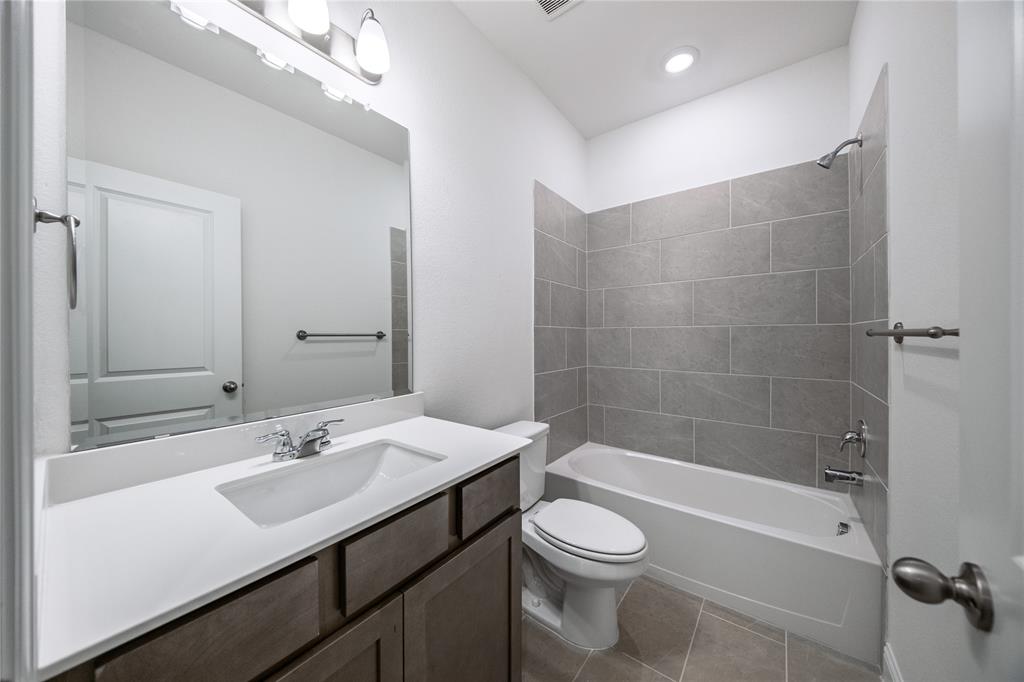 102 National Court Forney, TX 75126 - Photo 19 of 26 a bathroom with a sink a toilet a mirror and bathtub