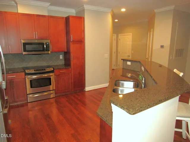 a kitchen with stainless steel appliances granite countertop a stove a sink and a microwave