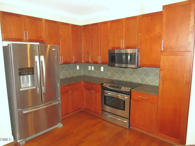 a kitchen with granite countertop stainless steel appliances and wooden cabinets