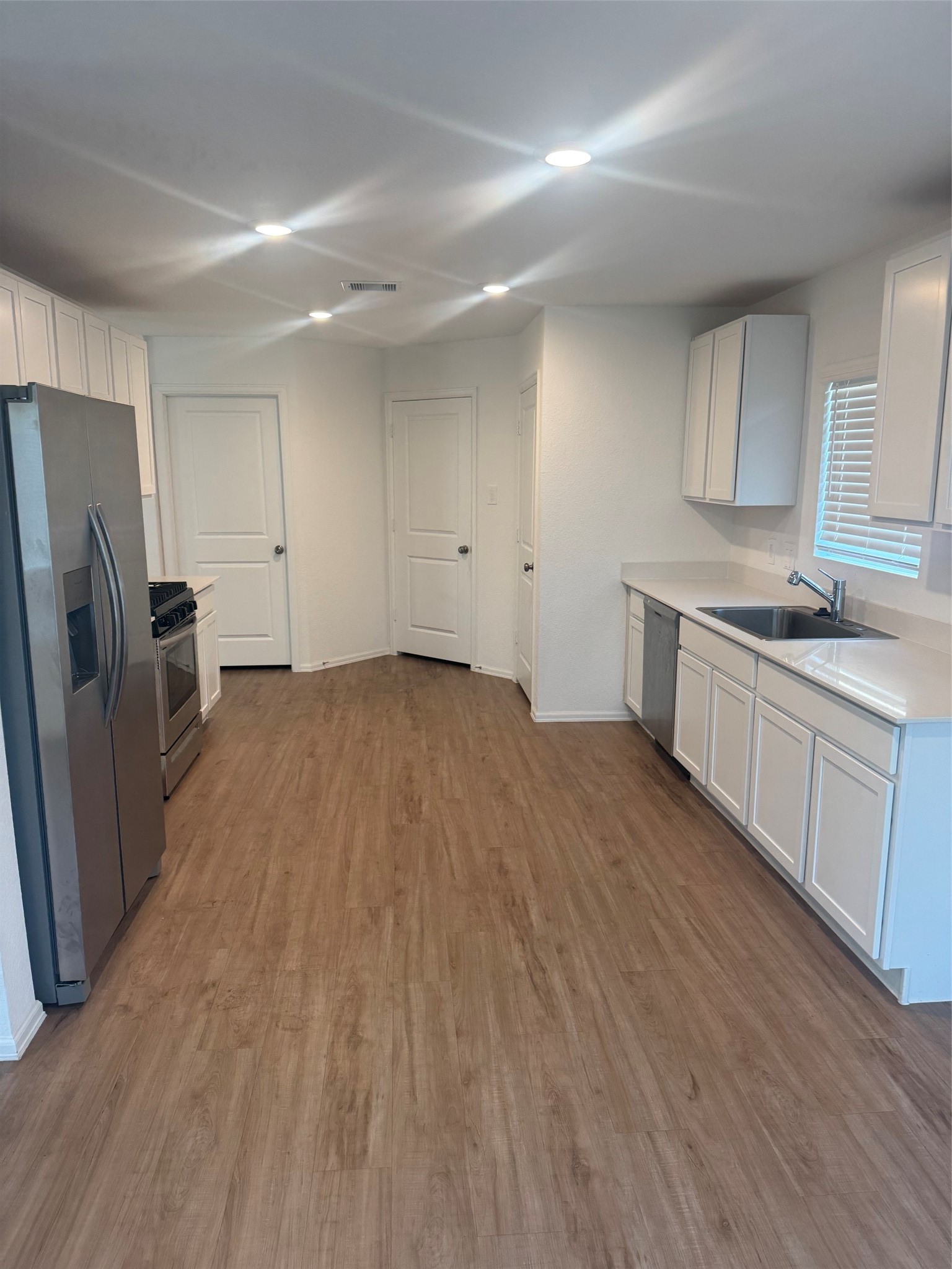 3202 Holly Stokes Way Conroe, TX 77301 - Photo 8 of 24 a kitchen with a sink a refrigerator and cabinets