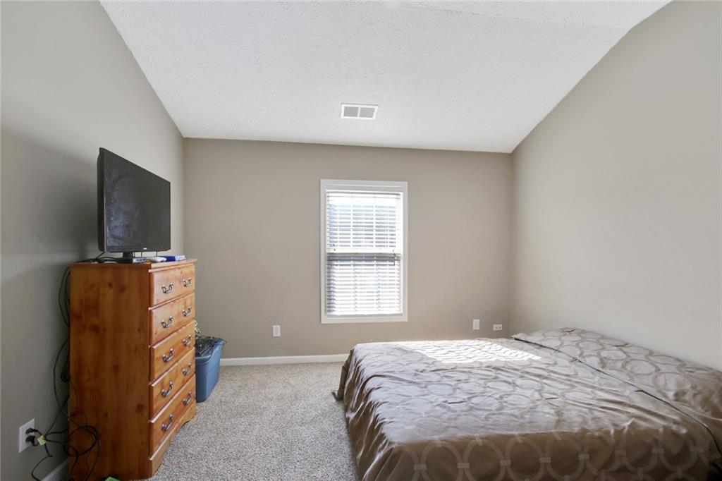 2555 Flat Shoals Road, Unit 1801 Atlanta, GA 30349 - Photo 17 of 24 a bedroom with a bed and flat screen tv