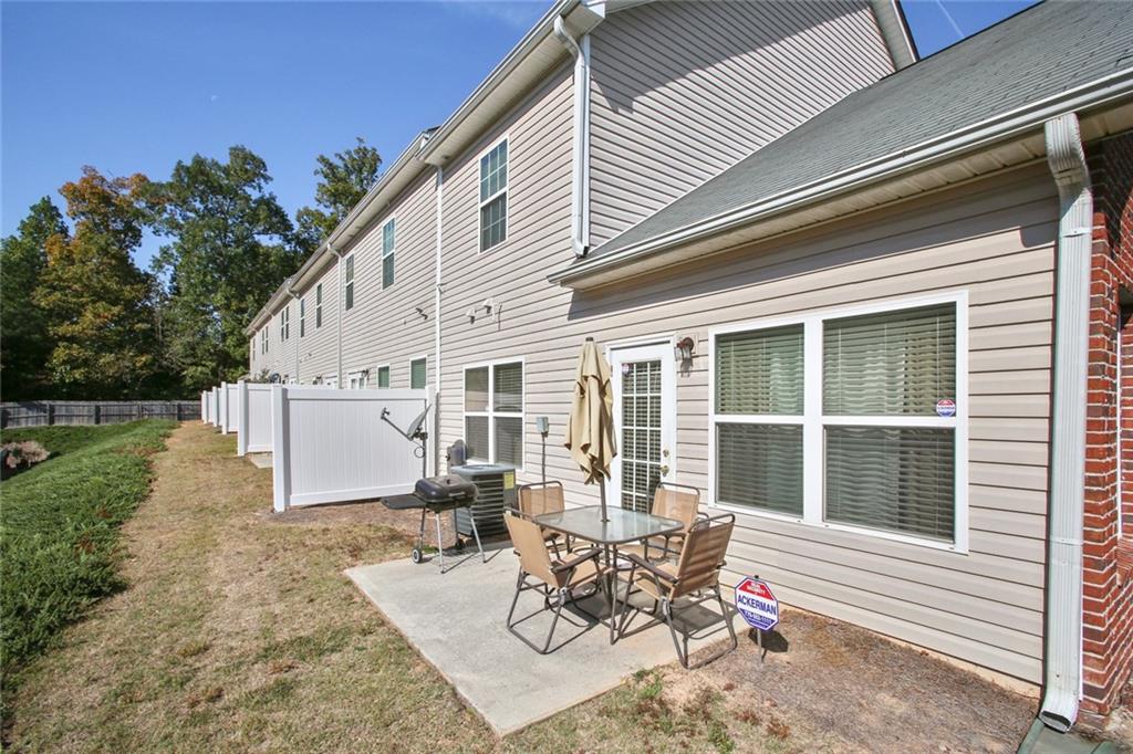 2555 Flat Shoals Road, Unit 1801 Atlanta, GA 30349 - Photo 20 of 24 a view of a patio with table and chairs with wooden fence