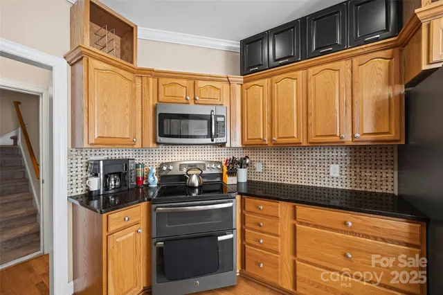a kitchen with stainless steel appliances granite countertop a stove a sink and a microwave