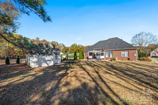 a view of a big house with a big yard and large trees