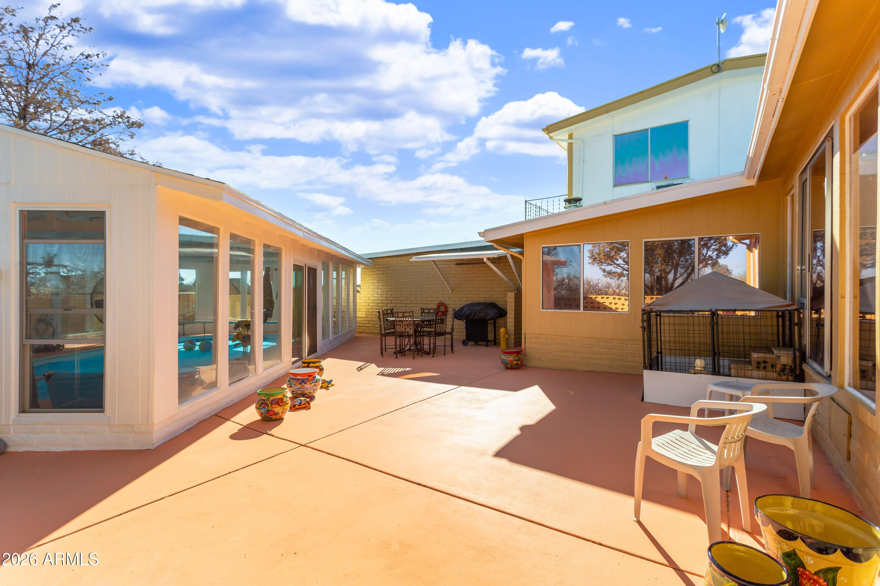 5681 South Moson Road Hereford, AZ 85615 - Photo 13 of 47 a view of a patio with couches table and chairs under an umbrella