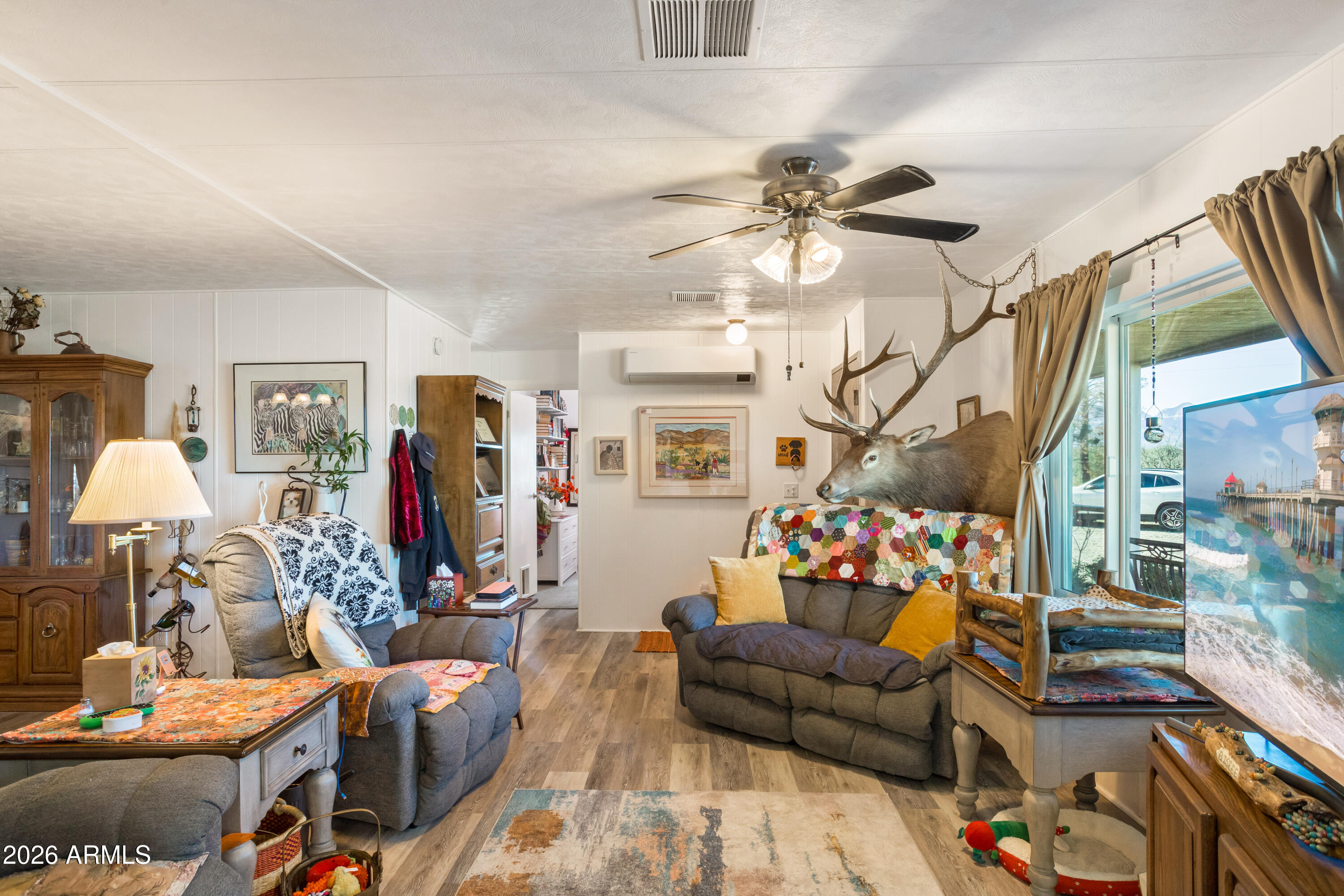 5681 South Moson Road Hereford, AZ 85615 - Photo 32 of 47 a living room with furniture a chandelier and a flat screen tv