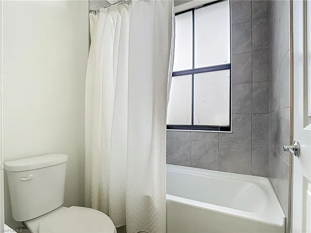a white bath tub sitting next to a toilet