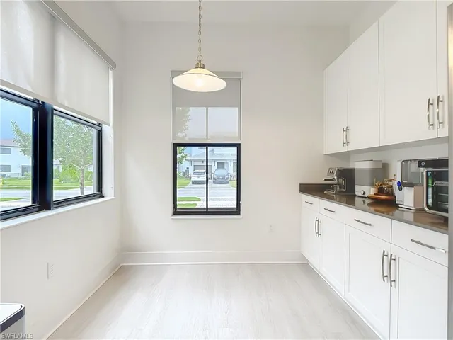 a kitchen with granite countertop a sink window and cabinets