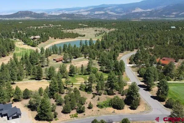 an aerial view of a house with a yard and lake view