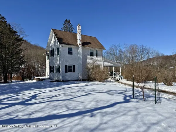 a view of a house with a snow in the background