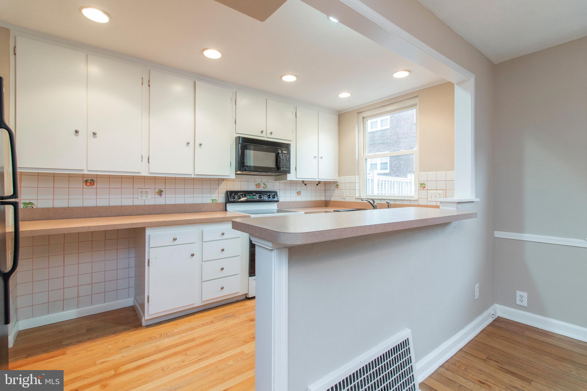 244 Barclay Road Upper Darby, PA 19082 - Photo 8 of 21 a kitchen with kitchen island granite countertop a sink cabinets and wooden floor