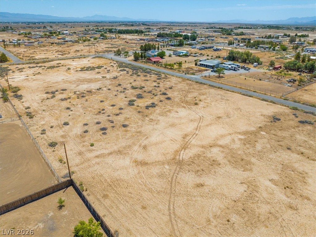 4610 Lawrence Road Pahrump, NV 89048 - Photo 28 of 42 A vast, open lot ready for development, framed by distant mountains and a clear sky.
