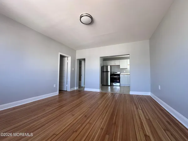 a view of empty room with wooden floor