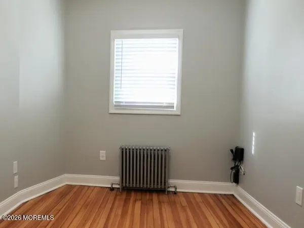 a view of a room with wooden floor and a window