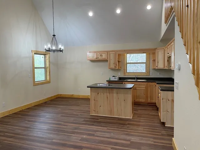 a kitchen with granite countertop a stove and a wooden floors