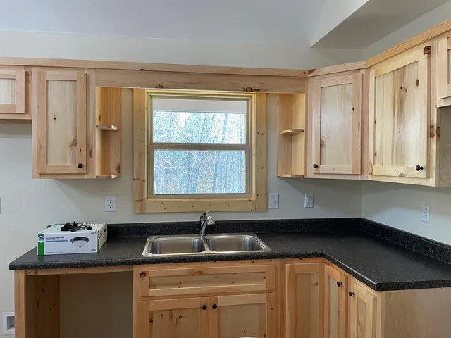 a kitchen with a sink cabinets and window