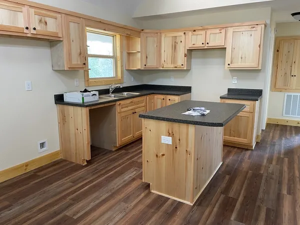 a kitchen with granite countertop a sink stove and cabinets