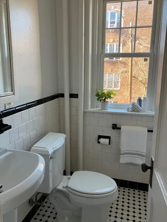 a bathroom with a toilet a sink and a window
