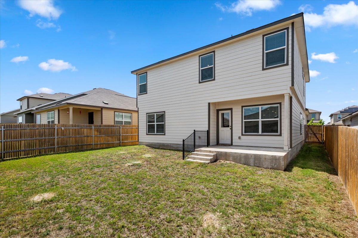448 Perfect World Loop Jarrell, TX 76537 - Photo 5 of 40 A fenced backyard offers privacy and space for outdoor activities, complementing the home's contemporary siding and windows.