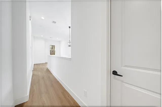 a view of a hallway with wooden floor