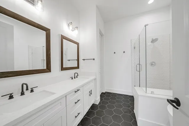 a bathroom with a double vanity sink mirror and bathtub