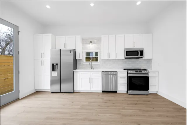 a kitchen with stainless steel appliances a refrigerator stove and microwave