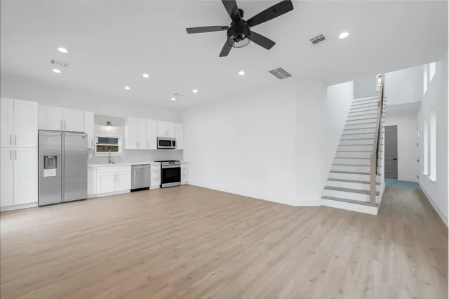 a view of a kitchen with wooden floor and electronic appliances