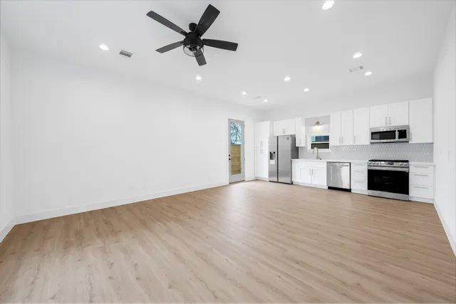a view of a kitchen with a sink oven cabinets and wooden floor
