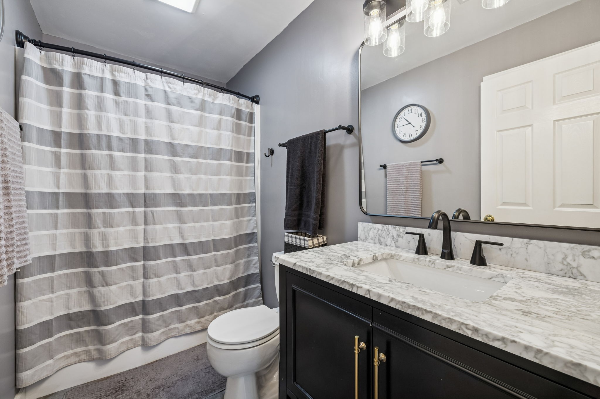 7697 Bethany Church Road Orlinda, TN 37141 - Photo 26 of 96 a bathroom with a granite countertop sink a toilet a mirror and shower curtain
