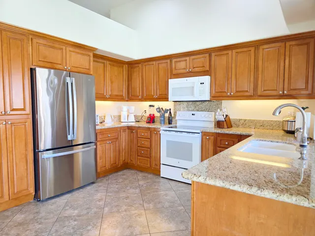 a kitchen with a refrigerator sink and cabinets