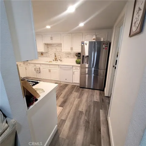 a kitchen with a sink a stove a refrigerator and white cabinets
