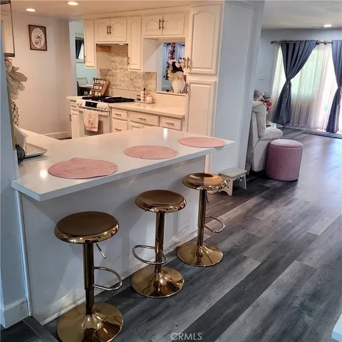 a kitchen with stainless steel appliances granite countertop a stove and white cabinets