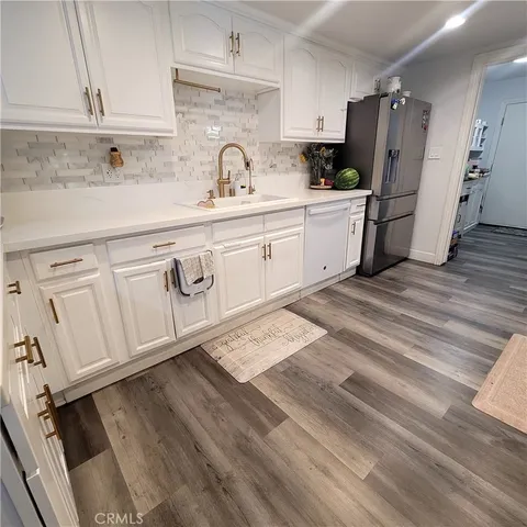 a kitchen with white cabinets and refrigerator