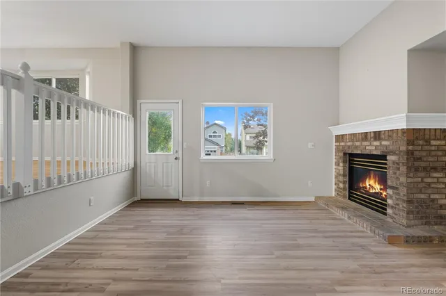 a view of empty room with wooden floor and fireplace
