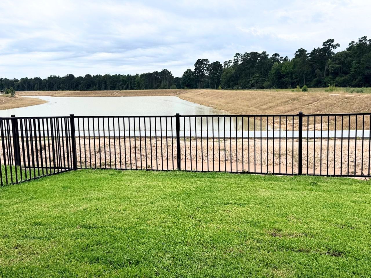 16246 Parish Pointe Court Conroe, TX 77302 - Photo 30 of 32 a view of a green field with a lake