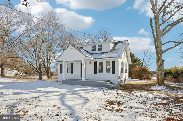 a front view of a house with a yard covered with snow
