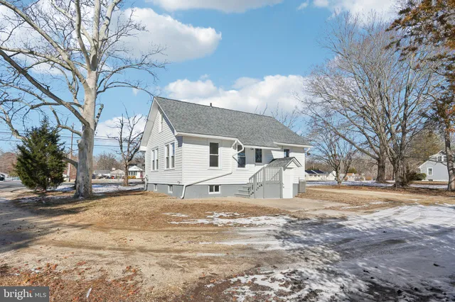 a front view of a house with a yard covered in snow