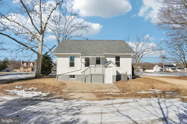 a view of a white house with a yard covered in snow