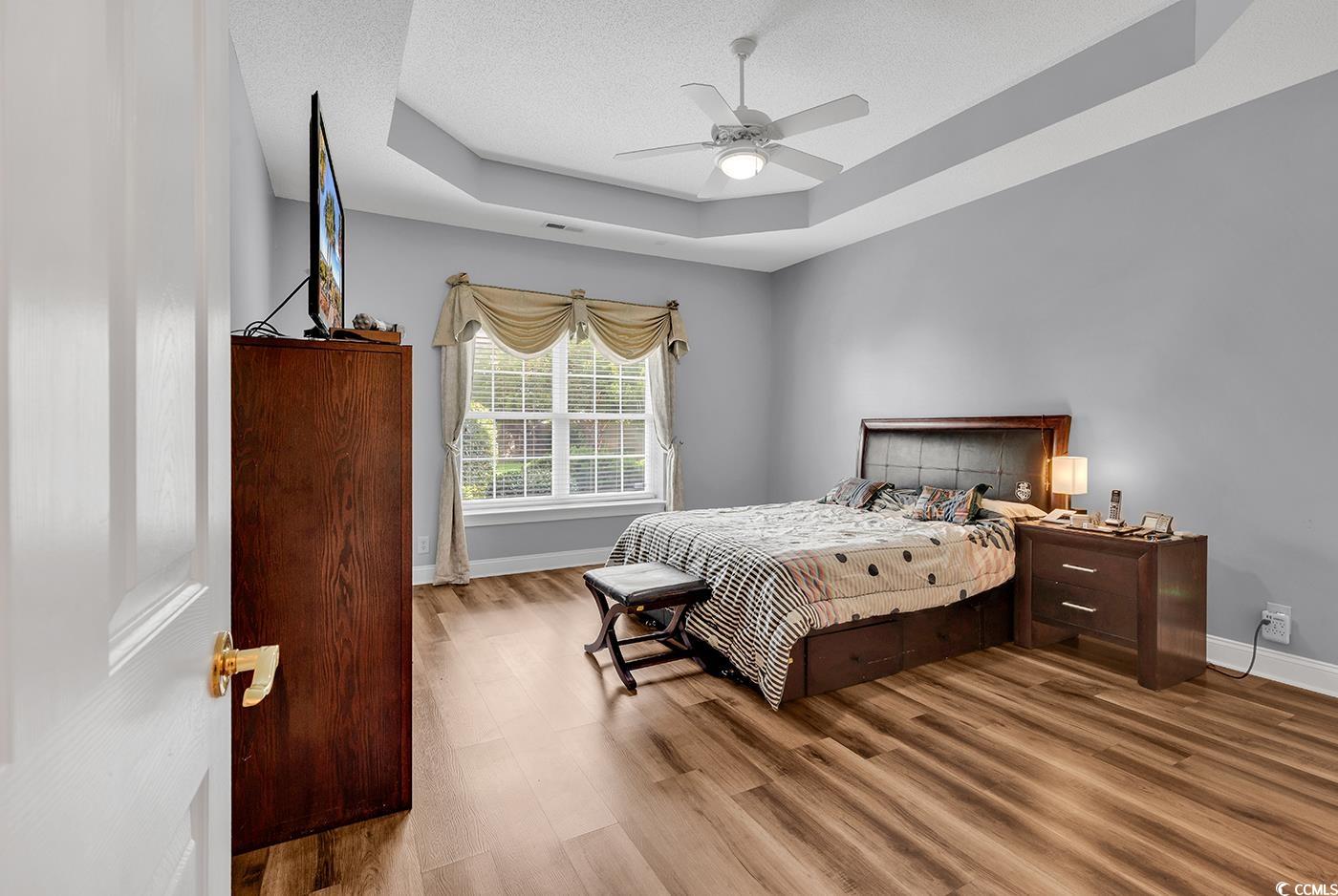 1459 St Thomas Circle, Unit F2 Myrtle Beach, SC 29577 - Photo 11 of 31 Bedroom with a tray ceiling, LVP flooring, and a ceiling fan