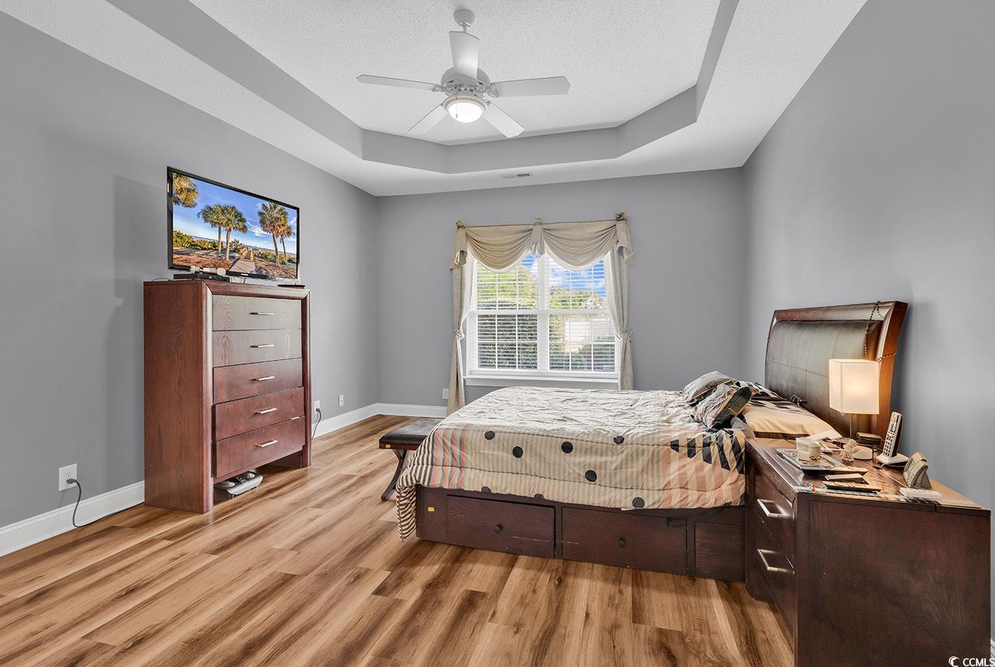 1459 St Thomas Circle, Unit F2 Myrtle Beach, SC 29577 - Photo 12 of 31 Bedroom with a tray ceiling, LVP flooring, and a ceiling fan