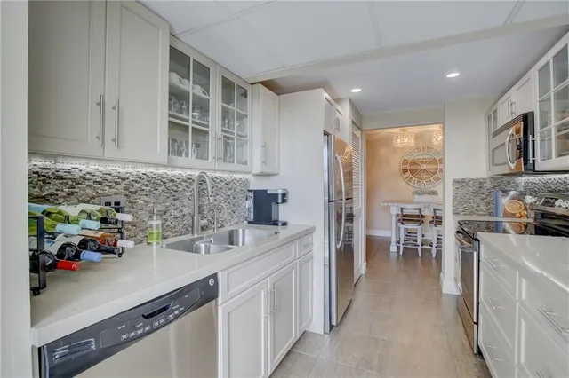 a kitchen with stainless steel appliances a sink a counter top space cabinets and a sink