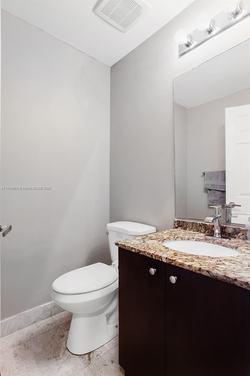 4458 Stone Ridge Way Weston, FL 33331 - Photo 32 of 45 a bathroom with a granite countertop sink toilet and mirror
