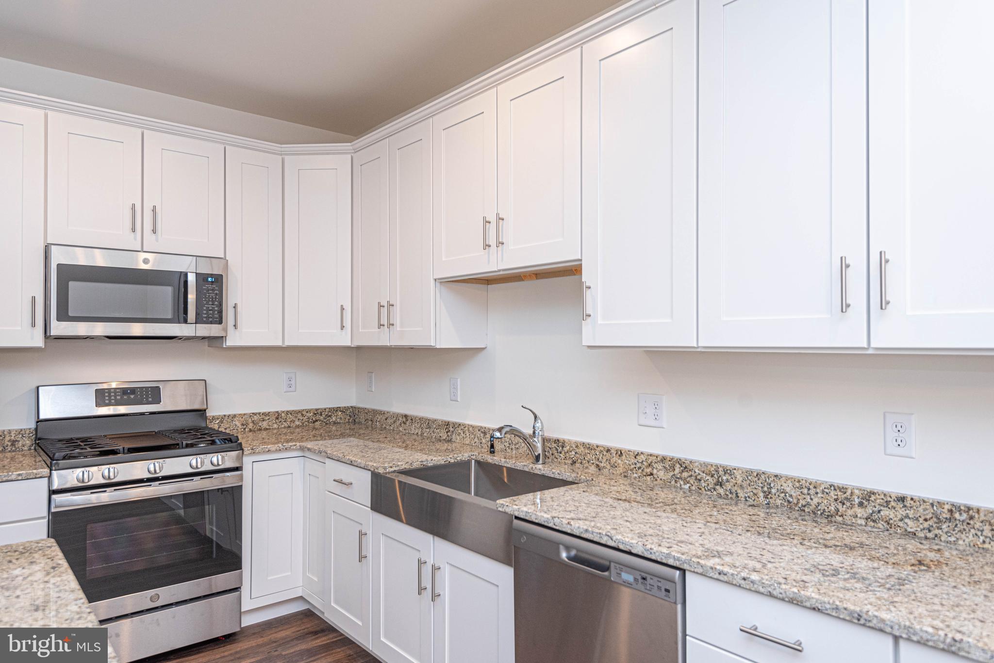 211 Prospect Street Milton, DE 19968 - Photo 19 of 64 a kitchen with granite countertop white cabinets and stainless steel appliances