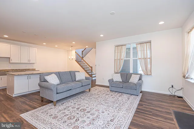 a living room with furniture and kitchen view