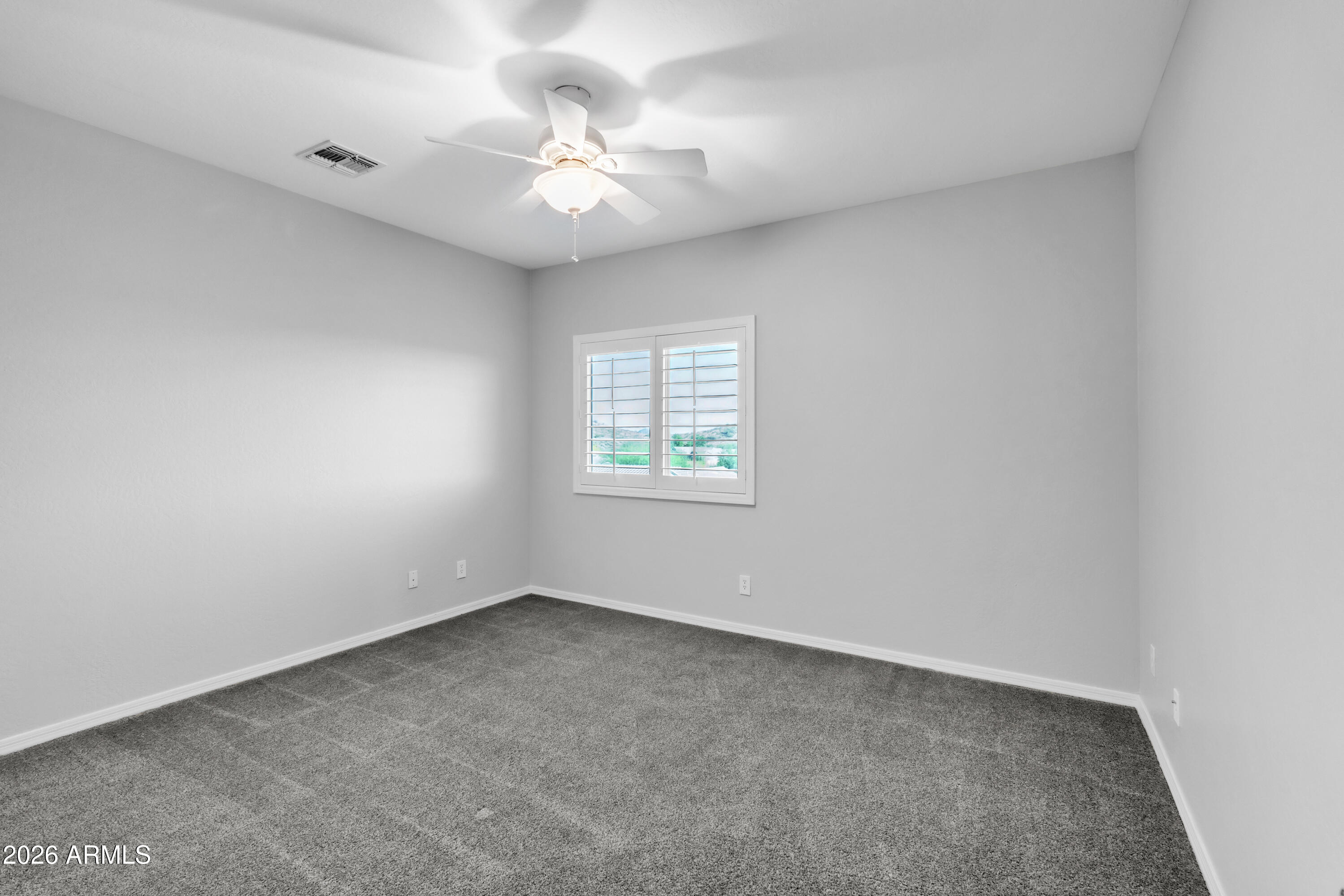 1615 West Red Fox Road Phoenix, AZ 85085 - Photo 43 of 64 an empty room with a chandelier fan and windows