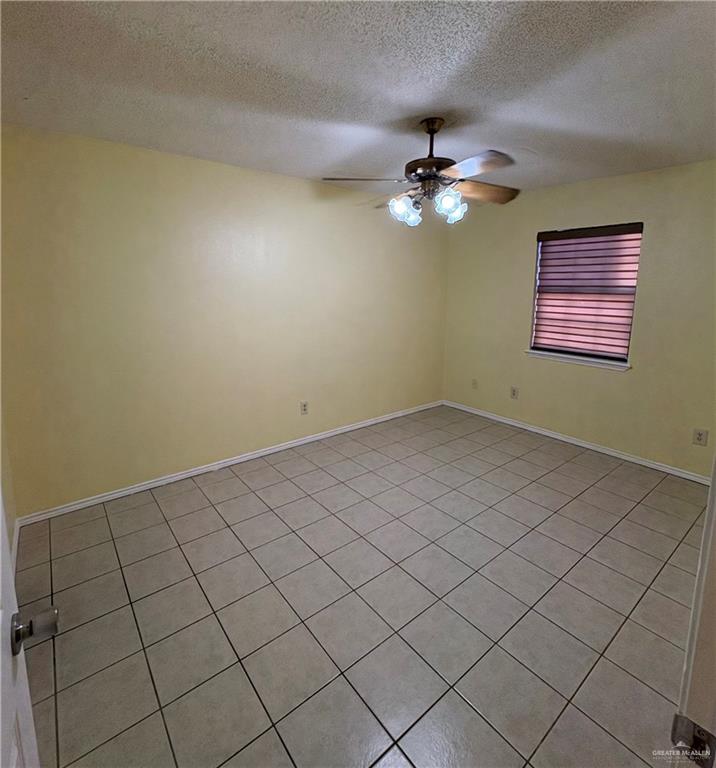 2301 North Stewart Road, Unit 2 Mission, TX 78574 - Photo 4 of 10 Empty room featuring a textured ceiling, a ceiling fan, and light tile patterned floors