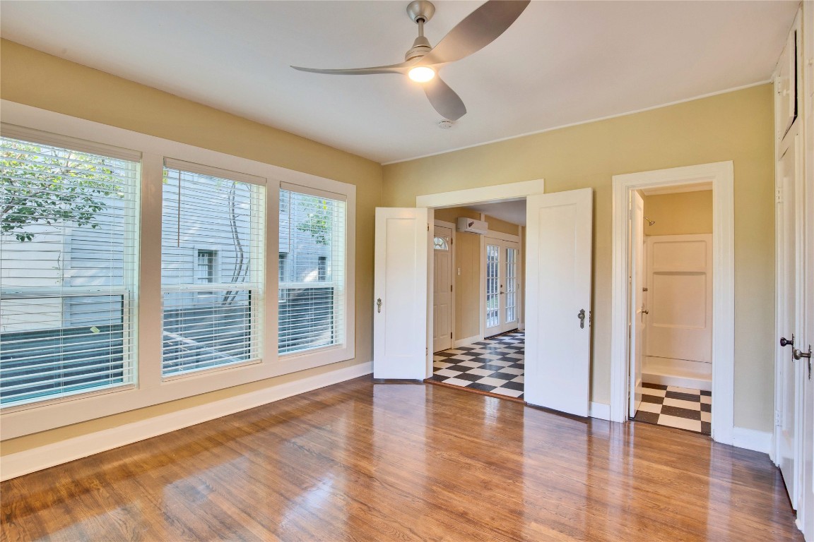 1115 Enfield Road, Unit A Austin, TX 78703 - Photo 15 of 21 a view of an empty room with wooden floor and a window