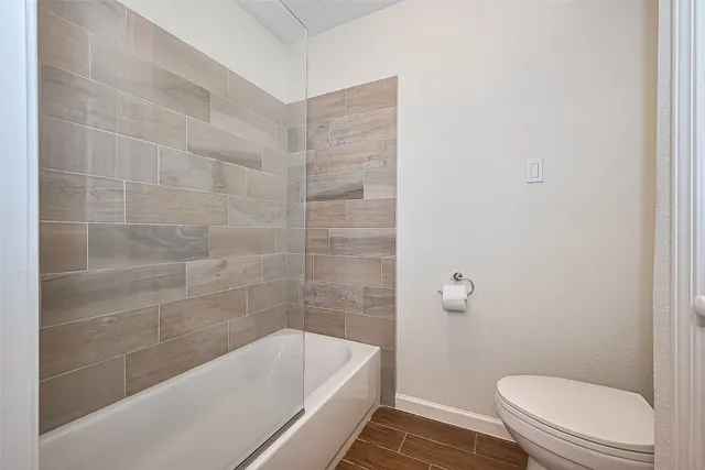 a bath room with a toilet and a bath tub